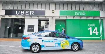  ??  ?? Singapore-based Grab is taking over the ride-sharing and food delivery operations of Uber in the region, with the California-headquarte­red company to receive a 27.5 per cent stake in the business in return. — Reuters photo