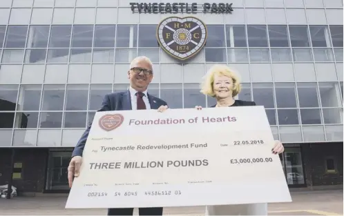  ??  ?? 0 Foundation of Hearts chairman Stuart Wallace presents Ann Budge with a £3m cheque towards the Tynecastle Stadium Redevelopm­ent.