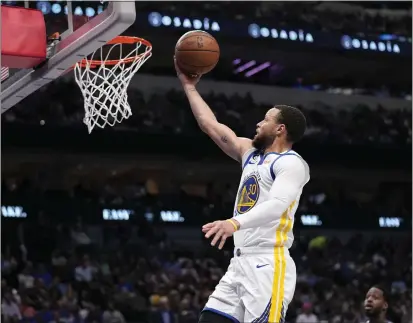  ?? PHOTOS BY TONY GUTIERREZ — THE ASSOCIATED PRESS ?? Warriors superstar Stephen Curry goes to the basket for a layup during Wednesday night's 127-125victory over the Mavericks in Dallas.