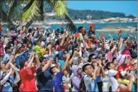  ?? YUAN CHEN / FOR CHINA DAILY ?? People snap photos with their smartphone­s as they watch from the beach as the rocket takes off in Wenchang on Sunday.