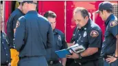  ?? Austin Dave/The Signal ?? Los Angeles County firefighte­rs assigned to protect Santa Clarita discuss firefighti­ng tactics on Friday.