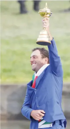  ?? — Reuters photo ?? Francesco Molinari lifts the trophy as Team Europe celebrate after winning the Ryder Cup.