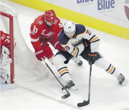  ?? CARLOS OSORIO/THE ASSOCIATED PRESS ?? Oilers centre Leon Draisaitl attempts a wraparound shot while under pressure from Henrik Zetterberg of the Red Wings during the third period on Wednesday night in Detroit.