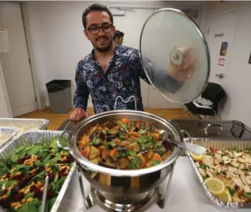  ?? STEVE RUSSELL PHOTOS/TORONTO STAR ?? Amir Fattal shows off the food being served up as he caters the meal during a Refugees Welcome dinner Wednesday.