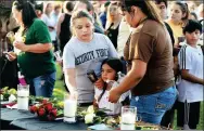  ?? TRISH BADGER / REUTERS ?? People place flowers on a table during a vigil held at the Texas First Bank after the shooting at Santa Fe High School in Texas, which left 10 people dead.