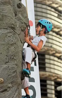  ??  ?? Aiming high: A young boy trying rock climbing during Hari Sukan Negara in Putrajaya