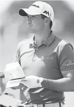  ??  ?? Jason Day looks at his yardage book in the sixth fairway during the first round of the RBC Canadian Open at Glen Abbey Golf Club in Oakville, Canada. — AFP photo