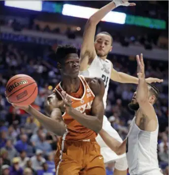  ?? MARK HUMPHREY — THE ASSOCIATED PRESS ?? Texas forward Mohamed Bamba passes under pressure from Nevada guard Kendall Stephens (21) and forward Caleb Martin, right, in an NCAA Tournament game in Nashville, Tenn., Friday, March 16, 2018.