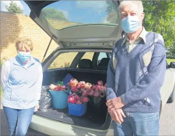  ?? Janice and John Williams and some of the flowers they are giving ?? COLOURFUL GIFTS: to people.