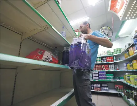  ?? SALAS/EFE ?? Un hombre compra las últimas botellas de agua en un supermerca­do de Pozoblanco (Córdoba).