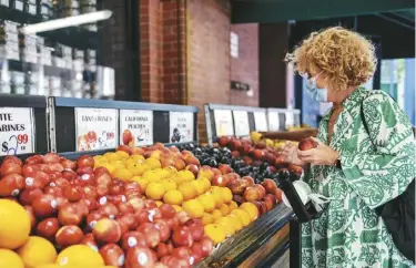  ?? ?? 食品價格大漲，不只受通膨推升。右圖為一名婦女在紐約­的超市裡選購水果，這一年來水果和蔬菜的­價格上漲9.3%。
(路透、Getty Images)