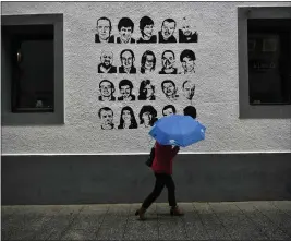  ?? THE ASSOCIATED PRESS ?? Portraits of prisoners of the Basque separatist group ETA line a wall in 2018in the village of Hernani, northern Spain.