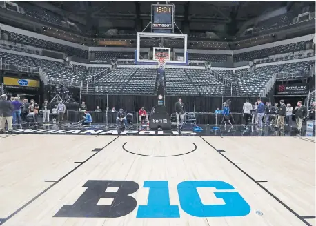  ??  ?? The seating area at Bankers Life Fieldhouse is empty as media and staff mill about Thursday in Indianapol­is, after the Big Ten announced that remainder of the tournament was canceled.