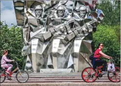  ?? -AFP ?? People ride bicycles near the monument to Podolsks cadets who died during World War-II in Podolsk some 40kms outside Moscow on Thursday.