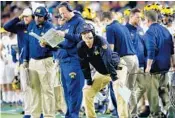  ?? CHRIS TROTMAN/GETTY IMAGES ?? Head coach Jim Harbaugh, center, of the Michigan Wolverines reacts in the first half of the Orange Bowl game Friday night against Florida State.