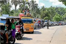  ?? PHOTO: REUTERS ?? A government troop stands on guard checking vehicles evacuating residents from their hometown of Marawi city in southern Philippine­s.