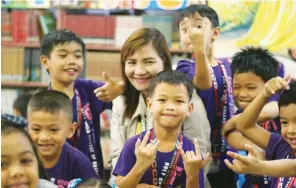  ??  ?? CITY Librarian Lelian Ortaliz of the Children's Department enjoy the hugs of the pupils from Holy Child School of Davao who performed a song as an act of gratitude to the staff of Davao City Library for being instrument­s to their learning process.