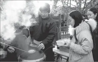  ?? ZHANG WEI / CHINA DAILY ?? People line up at Beijing’s Yonghe Lama Temple for free Laba rice porridge on Sunday. One tradition says that eating the porridge will bring happiness in the coming year.