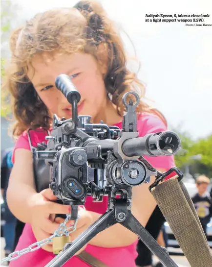  ?? Photo / Ilona Hanne ?? Aaliyah Eynon, 6, takes a close look at a light support weapon (LSW).