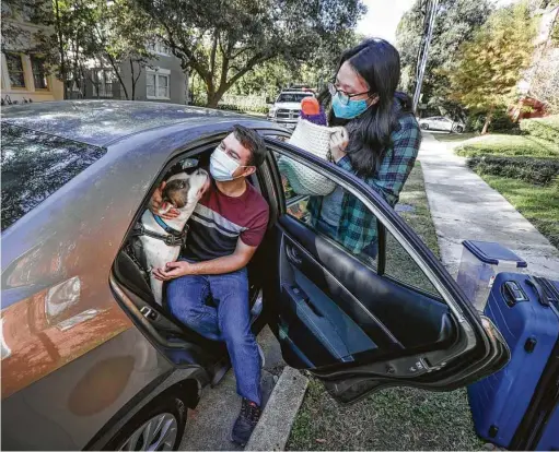  ?? Photos by Steve Gonzales / Staff photograph­er ?? Houston Chronicle reporter Gwendolyn Wu, her boyfriend Sean Booth and their dog Birch prepare to take a road trip from Houston to California to visit family for Thanksgivi­ng.