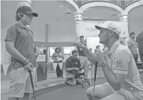  ?? BRANDON DILL/FOR THE COMMERCIAL APPEAL ?? St. Jude patient Dakota, 13, gets advice from profession­al golfer Bryson Dechambeau on Tuesday. PGA golfers visited St. Jude patients for a round of miniature golf on the campus of St. Jude Children's Research Hospital.