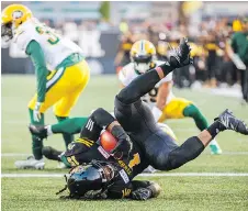  ?? MARK BLINCH/THE CANADIAN PRESS ?? Tiger-Cats running back Alex Green scores a touchdown against the Edmonton Eskimos in Hamilton’s come-from-behind 25-24 home win Thursday at Tim Horton’s Field.