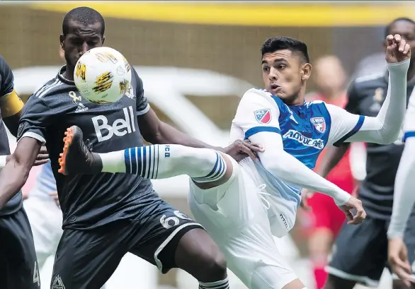  ?? DARRYL DYCK/THE CANADIAN PRESS ?? The Vancouver Whitecaps’ Ali Ghazal and FC Dallas’ Cristian Colman battle for the ball during Dallas’ 2-1 victory on Sunday at B.C. Place Stadium.