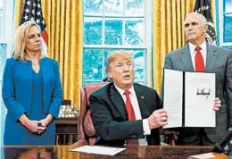  ?? JIM LO SCALZO/EPA ?? President Donald Trump, with Homeland Security chief Kirstjen Nielsen and Vice President Mike Pence, shows his order. The fate of children currently in custody is unclear.