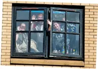  ??  ?? Waving at the world outside: Students at Glasgow University self-isolating