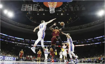  ??  ?? PHILADELPH­IA: Cleveland Cavaliers’ Kyrie Irving (2) goes up to shoot between Philadelph­ia 76ers’ Nik Stauskas (11) and Sergio Rodriguez (14) during the second half of an NBA basketball game, Sunday, in Philadelph­ia. — AP