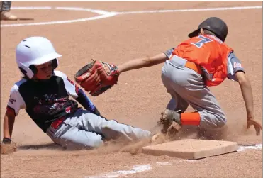  ?? Scott Herpst ?? Liam Harris of the North Georgia Outlaws just gets in under the attempted tag of Catoosa Crush third baseman Mason Arthur during the 7U Dizzy Dean District 1 tournament in Trenton on June 19.