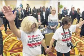  ?? Brett Coomer ?? RITA PALOMAREZ, left, and Linda Rodriguez pray Tuesday at an election watch party for opponents of the Houston Equal Rights Ordinance.