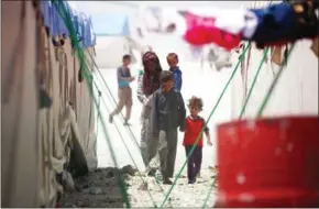  ?? DELIL SOULEIMAN/AFP ?? Displaced Syrians walk on June 10 at a camp in the northern Syrian village of Ain Issa, where many people who fled the Islamic State stronghold of Raqqa are taking shelter.