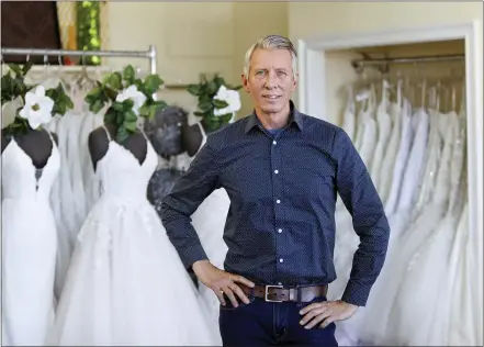  ?? AP PHOTO/TERESA CRAWFORD ?? David Gaffke, owner of the bridal salon Complete Bridal, poses in his shop in East Dundee, Illinois, on Feb. 28. He is heavily reliant on China for manufactur­ing. “It’s frustratin­g when it comes to having to tell a bride that we’re not able to fulfill your needs,” he said. “This is the most important dress they’re going to wear.”