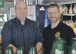  ?? NIKKI SULLIVAN/CAPE BRETON POST ?? Colin Rankin and Capt. John Boudreau stand behind the bar at the Victoria Park officers mess during a Father’s Day social.