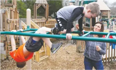  ?? STAFF FILE PHOTO BY C.B. SCHMELTER ?? Charity Langley helps her 4-year-old son, Jeremiah, as he and his 6-year-old brother, Isaiah, play at the Imaginatio­n Station playground in Collegedal­e in March. The playground is a perfect spot for a free summer picnic and playtime with the kids.