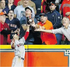  ?? BOB LEVEY / GETTY IMAGES ?? Mookie Betts of the Boston Red Sox jumps at the wall Wednesday as he attempts to make a catch in Houston.