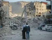  ?? CHRIS MCGRATH/GETTY ?? A couple look over buildings destroyed by the Feb. 6 quake Sunday in Turkey’s Hatay province.