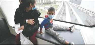  ??  ?? Yancarlos and his mother ride a tram between terminals during a layover at George Bush Internatio­nal Airport in Houston. A few days previously, Yancarlos was walking along a muddy river bank after crossing the Rio Grande and landing on the U.S. side of the border with Mexico. Ramirez said they turned themselves in to U.S. Border Patrol officers and later spent hours in custody, a night under a bridge and three more days in a detention facility.