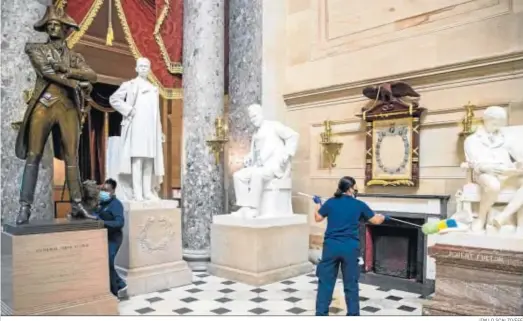  ?? JIM LO SCALZO/EFE ?? Operarios limpian una estatuas del Capitolio el día después del asalto.