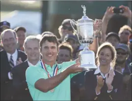  ?? The Associated Press ?? Brooks Koepka holds up the winning trophy after the U.S. Open on Sunday at Erin Hills in Erin, Wis. Koepka closed with a 5-under 67 for his first major championsh­ip.