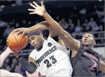  ?? ELISE AMENDOLA/ASSOCIATED PRESS ?? Providence forward LaDontae Henton brings down a rebound against Cincinnati forward Titus Rubles during the first half.