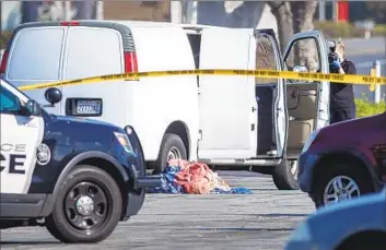  ?? Allen J. Schaben Los Angeles Times ?? A CORONER’S official assesses a van whose driver had died of a self-inflicted gunshot. The driver was confirmed to be Huu Can Tran, who earlier had opened fire at a dance studio in Monterey Park, killing 11 people.