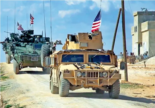  ?? — AP File ?? Fighters from the Syrian Democratic forces standing near US military vehicles on the outskirts of the Syrian town Manbij. The US has recently dispatched 400 Marines in northern Syria to fight Daesh.