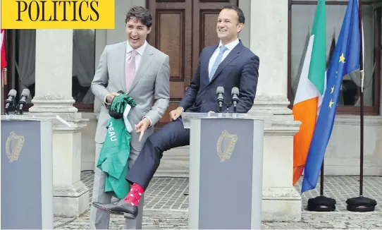  ?? PAUL FAITH/AFP/GETTY IMAGES ?? Prime Minister Justin Trudeau is presented with an Ireland rugby union shirt and pair of socks by Ireland’s Prime Minister Leo Varadkar, who shows off his own pair of Canadian socks in Dublin Tuesday. The leaders both took a swipe at their bigger...