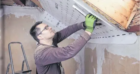  ?? FOTO: SEBASTIAN DORN/IMAGO IMAGES ?? Arbeiter bei der Dachdämmun­g: Hausbesitz­er können Fördermitt­el für einen Neubau wie auch für die energetisc­he Sanierung erhalten.