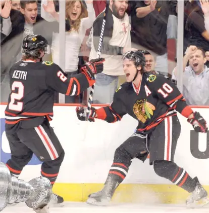  ?? SUN- TIMES ( ABOVE), GETTY IMAGES ?? Patrick Sharp ( above) celebrates with Duncan Keith after scoring in 2009. At left, Sharp hoists the Stanley Cup after the Hawks won it in 2010.