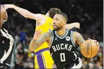  ?? ?? Milwaukee Bucks’ Damian Lillard gets past Los Angeles Lakers’ Austin Reaves during the second half of an NBA basketball game Tuesday, March 26, 2024, in Milwaukee. The Lakers won 128-124 in double overtime. (AP)