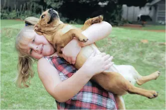  ?? | ANTOINE DE RAS ?? IZANDRI Nel, 6, who survived a liver transplant at the age of 6 months, enjoys some fun time with her favourite dog, Aerial in this 2013 file photo. Dog owners have had more time to spend with pets during lockdown.