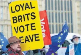  ??  ?? •Ae pro-brexit protester holds a placard outside the Palace of Westminste­r in London on Wednesday.